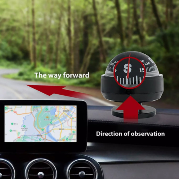 Black car dashboard compass ball mounted near windshield with red directional needle