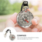 Mini compass keychain held in hand, black strap, silver dial with red needle