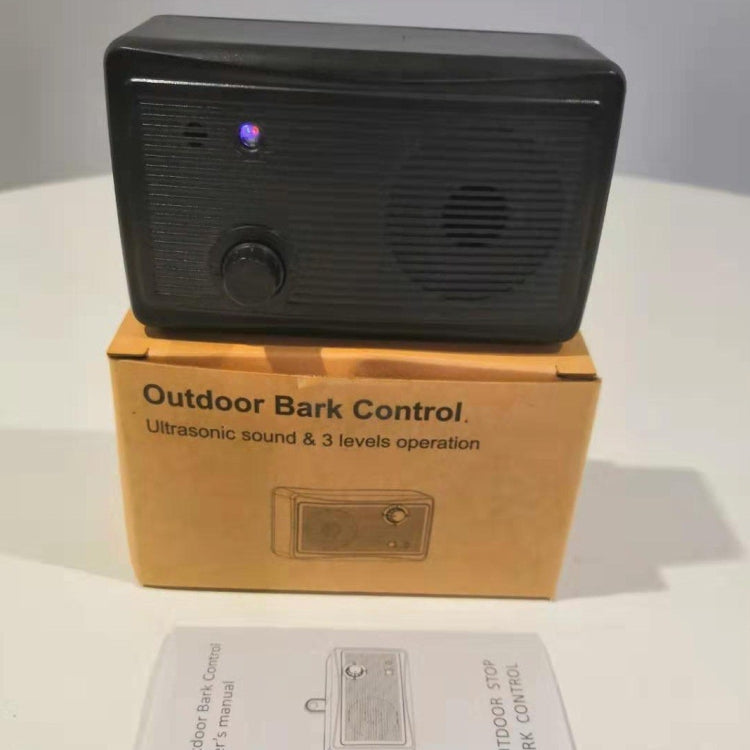 Black ultrasonic bark control dog training device resting on retail box