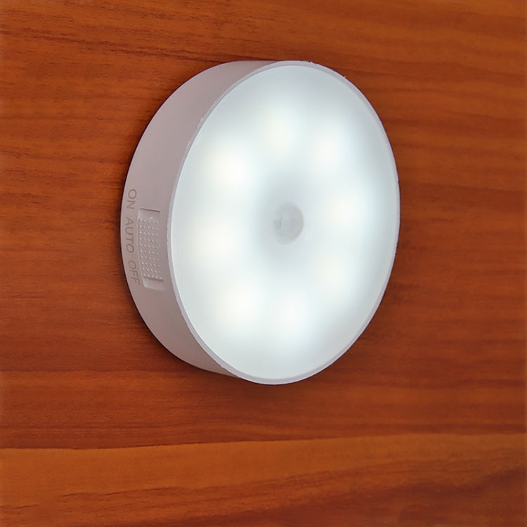Round LED night light, gray outer ring with bright white lens and small sensor window