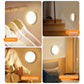 Round LED night light in use on wardrobe and staircase, warm glow