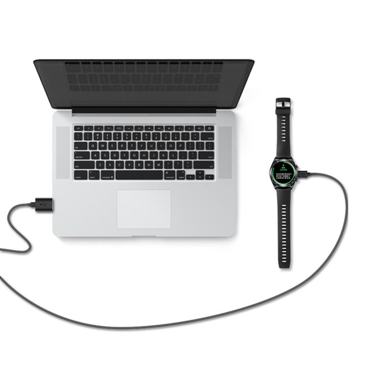 Smartwatch connected by charging cable to a laptop USB port
