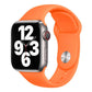 Orange silicone Apple Watch band with pin-and-tuck closure, shown on a watch.