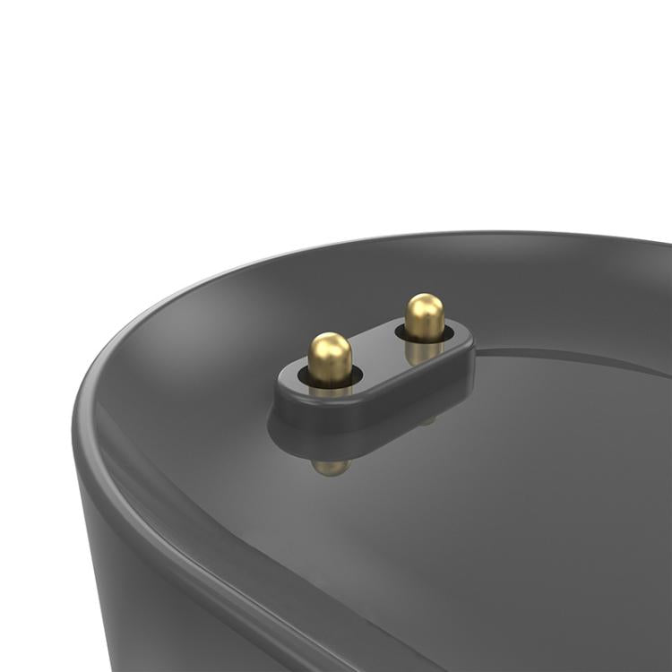 Close-up of the xDfind watch charger's two gold magnetic charging pins