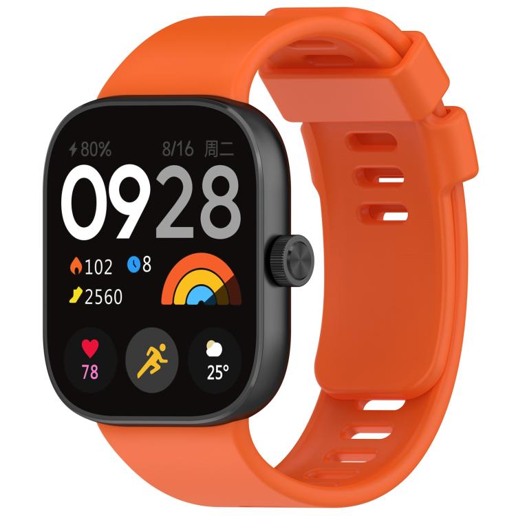 Orange silicone sports watch band fitted to a black smartwatch, with buckle and adjustment holes.