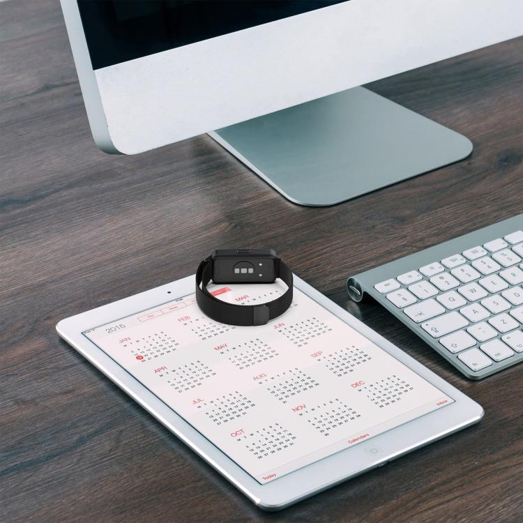Black watch band looped on a desk calendar