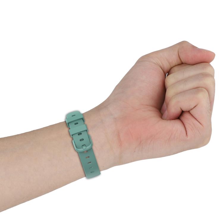 Teal silicone watch band with adjustable buckle, shown on a wrist