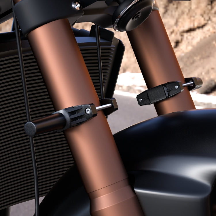 Black spotlight mounting bracket attached to motorcycle frame tubes with clamp