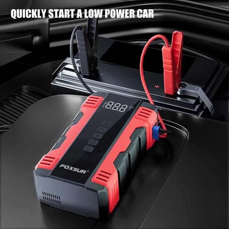 Red-and-black FOXSUR jump starter air compressor in a car cargo area with cables