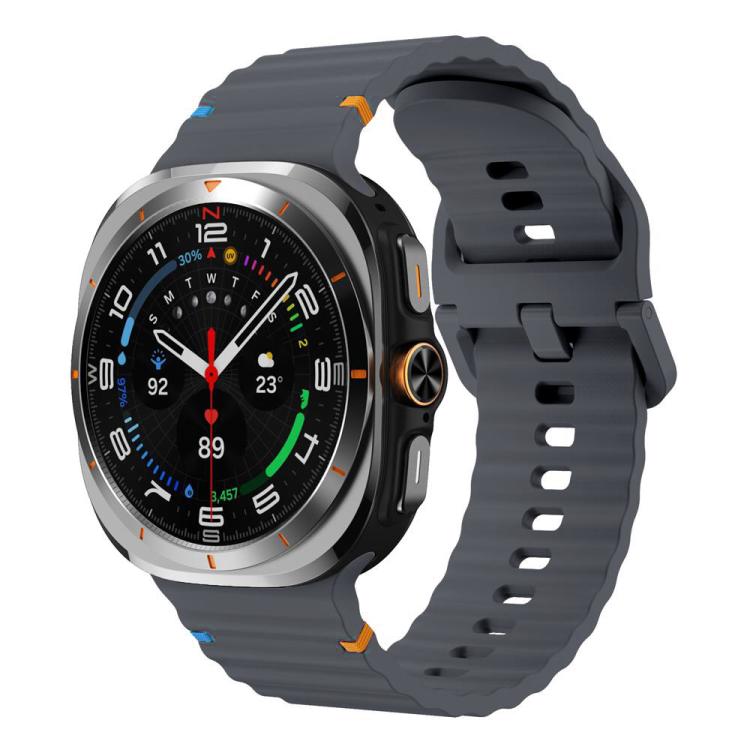 Charcoal gray silicone watch band with ridged texture and adjustable holes, shown on a Galaxy Watch