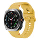 Yellow silicone watch band with ridged texture and adjustable holes, shown on a Galaxy Watch