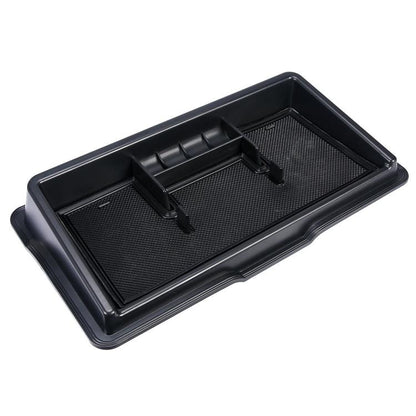 Black molded car dashboard storage box with textured base and raised dividers