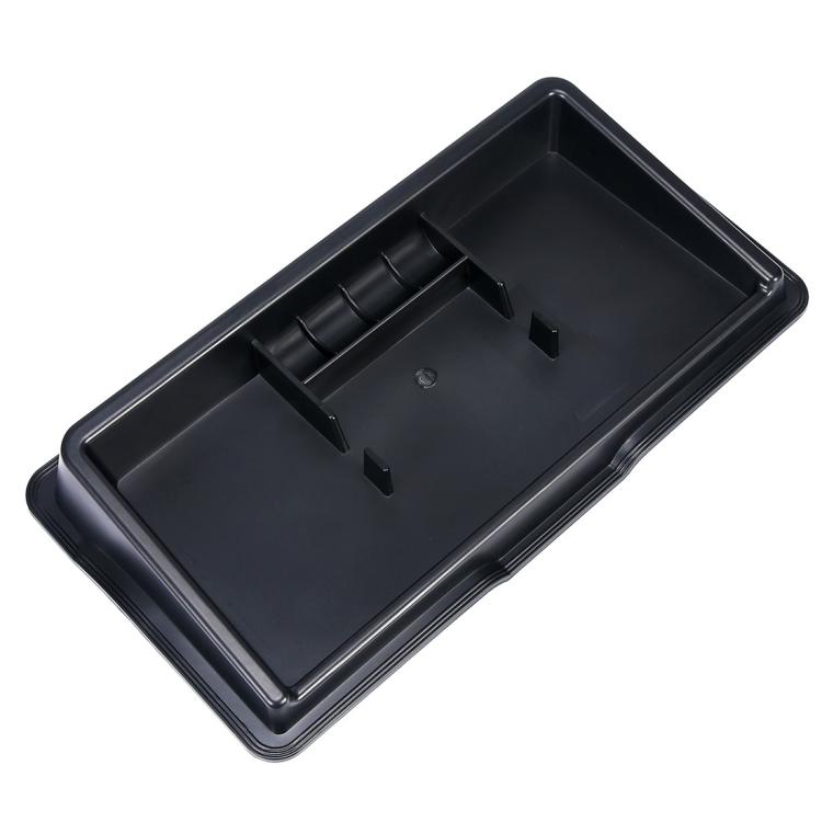 Black dashboard storage box with open interior and molded ridges, front view