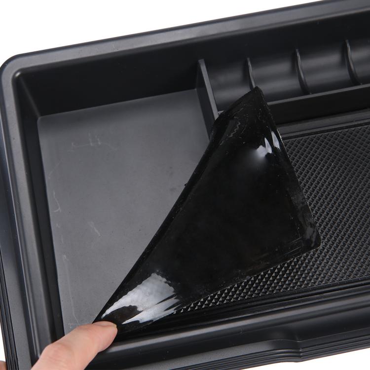 Black dashboard storage box with textured insert, hand peeling protective film