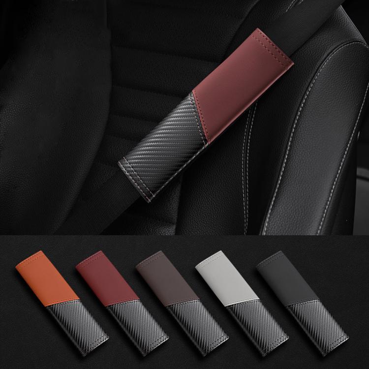 Red leather seat belt shoulder guard with carbon-fiber texture on car seat