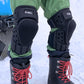 Motorcycle knee pads worn with red laced boots, black hard protectors over pant legs