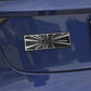 Rectangular carbon-fiber style sticker with white radial burst pattern on blue car panel