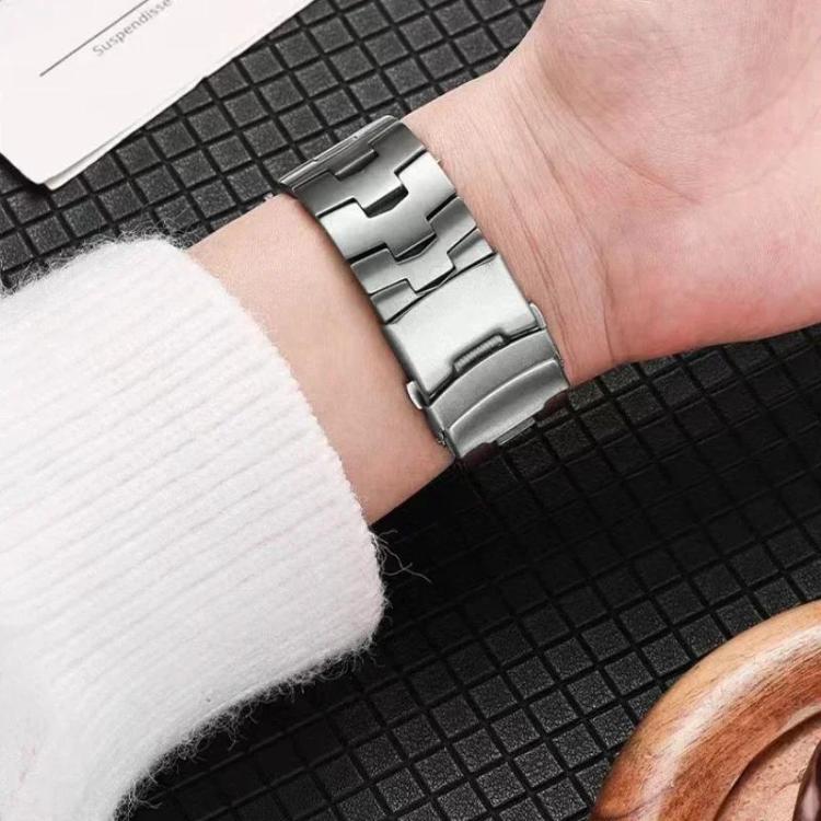 Silver titanium alloy watch band with wide links and safety buckle, worn on a wrist