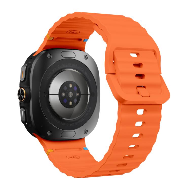 Orange silicone watch band with ridged texture, shown on the back of a Galaxy Watch Ultra2