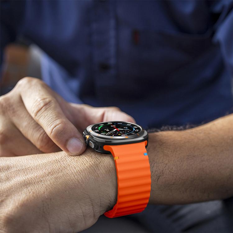 Orange silicone watch band with ridged detailing, worn on a wrist.
