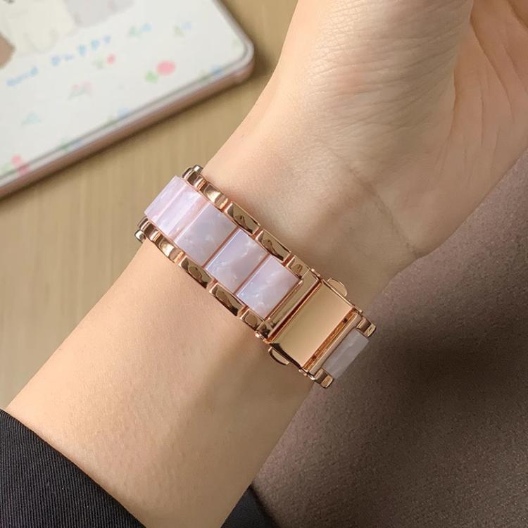 Rose gold metal watch band with pale pink resin links worn on a wrist.