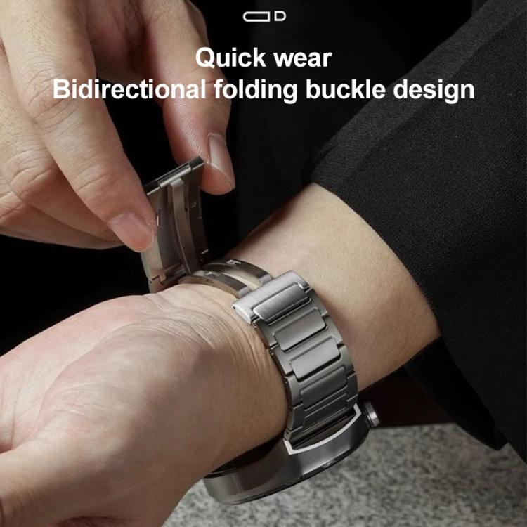 Silver stainless steel watch band with folding clasp being fastened around a wrist
