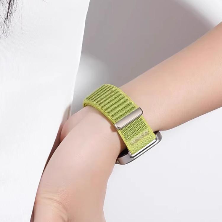 Lime green woven nylon watch band with adjustable metal loop on a wrist