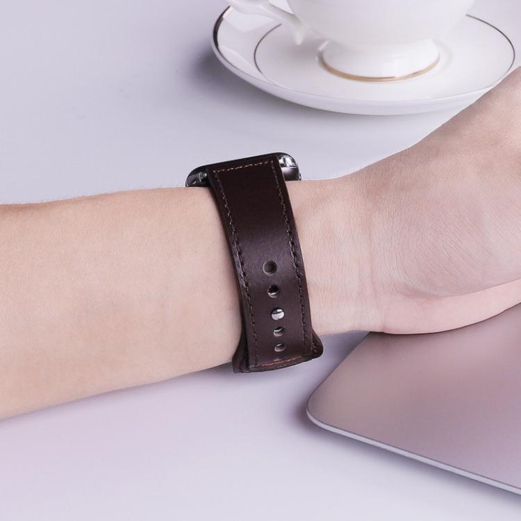 Dark brown leather watch band with stitched edges and adjustment holes, worn on the wrist