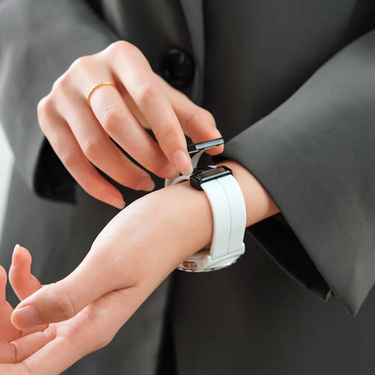 White silicone watch band being fastened around a wrist