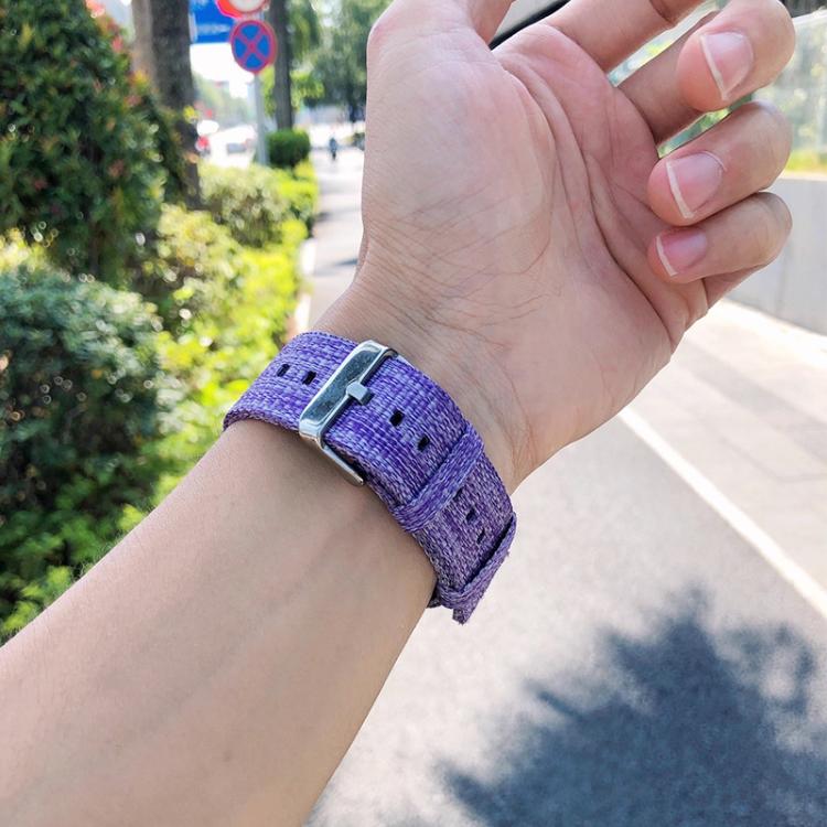 Purple nylon canvas watch band with metal buckle worn on a wrist