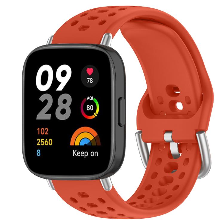 Red perforated silicone sport watch band with silver buckle on a black smartwatch