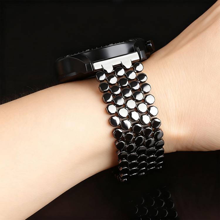 Black fish-scale metal watch band worn on a wrist