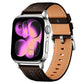 Brown and tan vegan leather watch band with stitched edges and silver buckle, shown on a watch