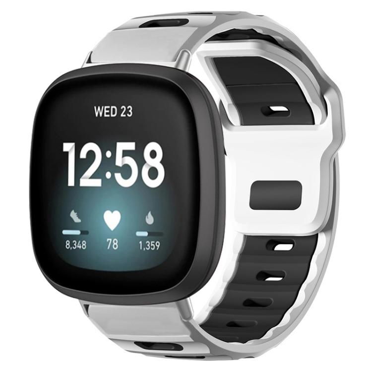 Fitbit silicone watch band in white and black, shown fitted to a smartwatch