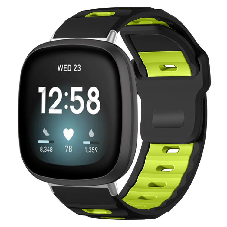 Fitbit silicone watch band in black and fluorescent green, shown fitted to a smartwatch