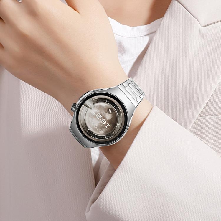 Silver linked metal watch band worn on a wrist with a round smartwatch.