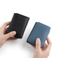 Black and blue RFID card storage bags held in hands, textured exterior