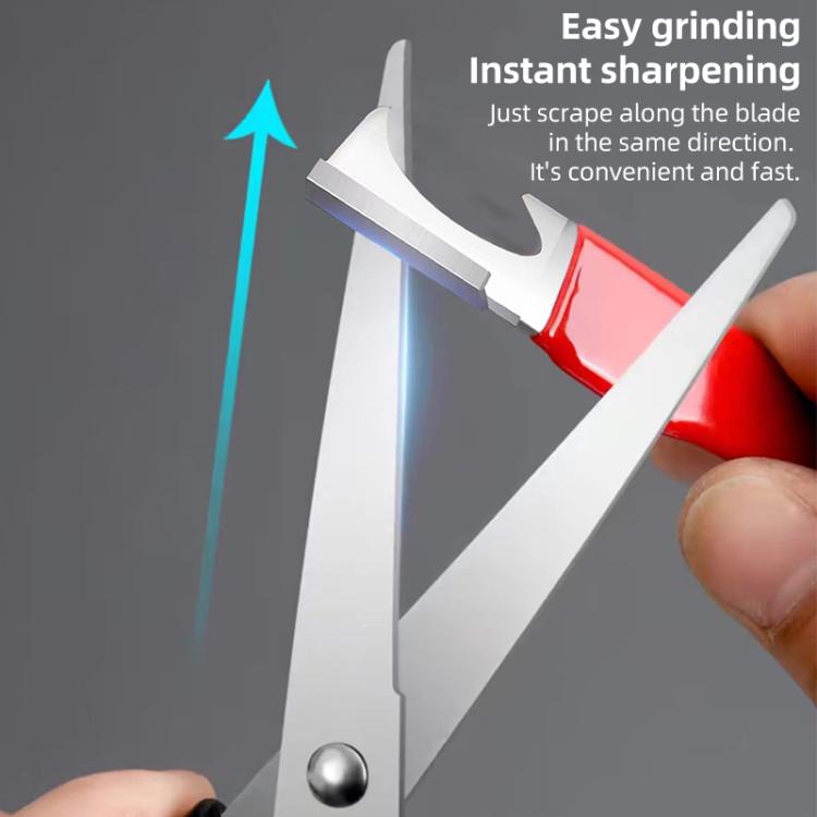 Red manual quick knife sharpener being used on a metal blade at an angle