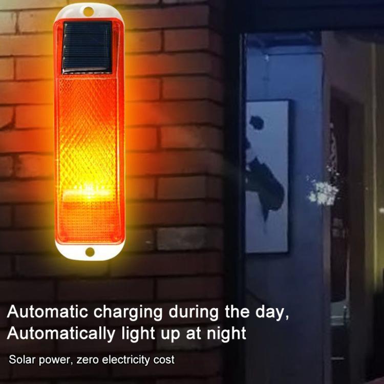 Solar LED warning light glowing amber through translucent lens with solar panel