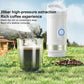 White portable coffee machine with blue button over a clear mug