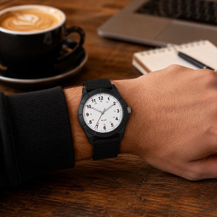 Black nylon-strap wristwatch with white face on a person’s wrist