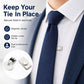 Metal magnetic tie clip fastened to navy tie on white dress shirt