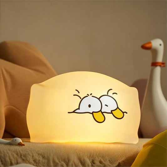Pillow-shaped duck night light with warm glow, soft white fabric and smiling duck design