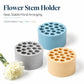 Plastic flower stem holder set in grey, blue, and beige cylindrical bases with holes