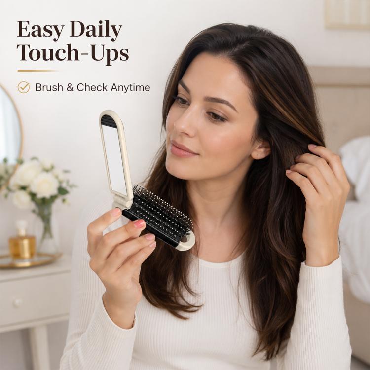 2-in-1 folding hairbrush with mirror, held in hand with black bristles visible