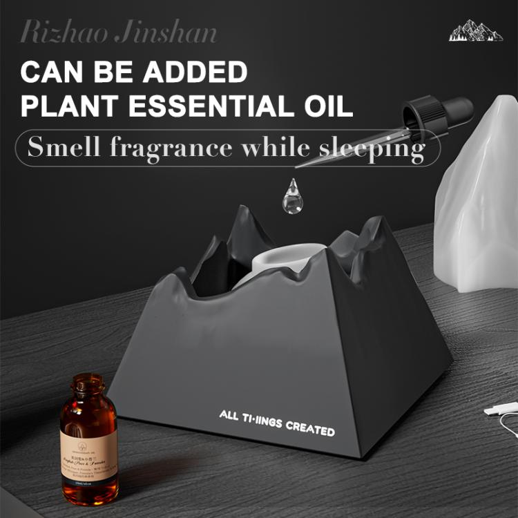 Dark grey mini volcano aroma diffuser night light with essential oil bottle nearby