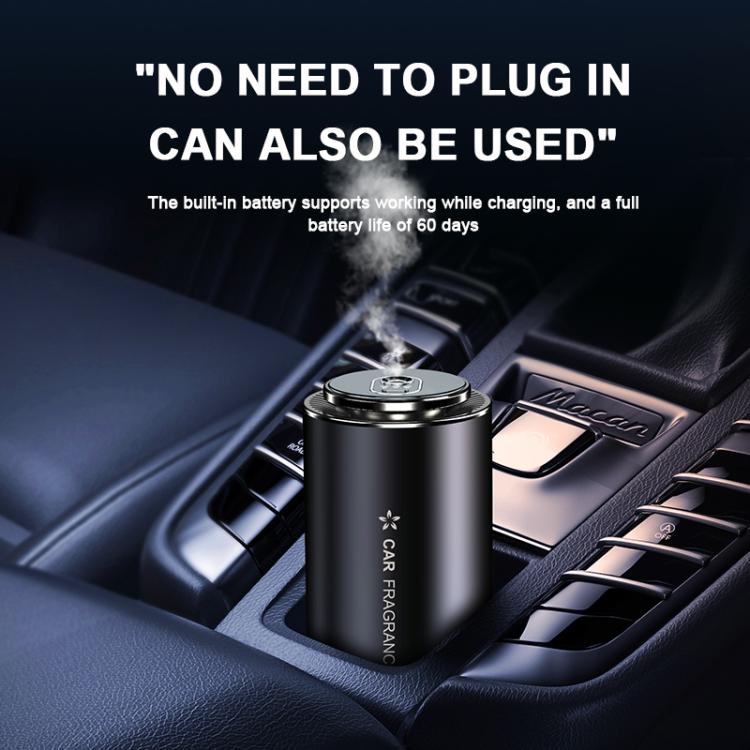 Black car aroma diffuser in a dashboard vent area, releasing a mist plume