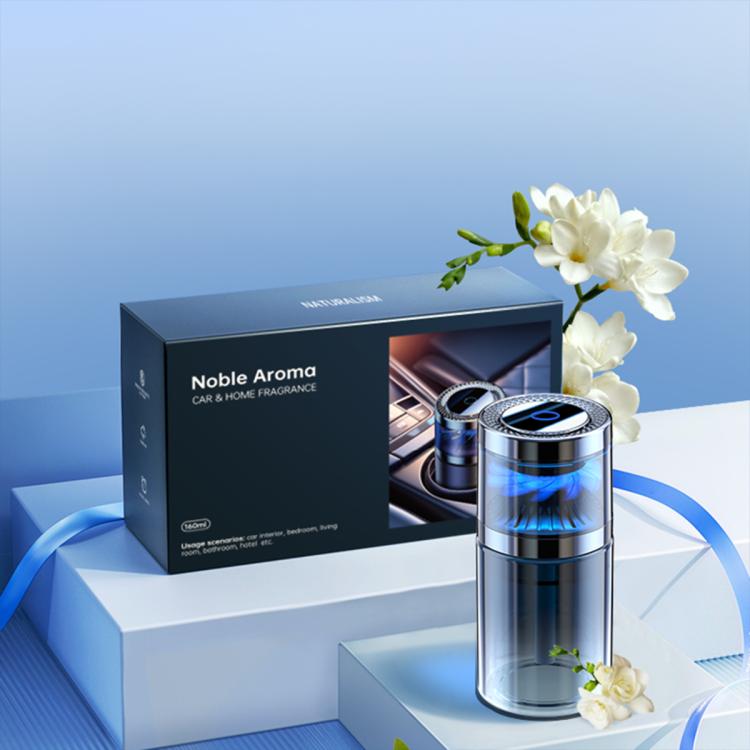 Silver car aroma diffuser beside product box, blue glow and clear chamber visible