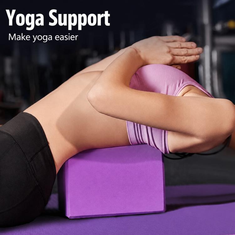 Purple yoga block supporting a seated stretch pose