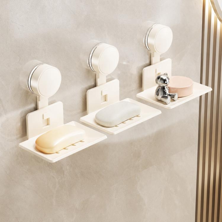 Three cream suction cup soap and sponge holders with drainable metal trays